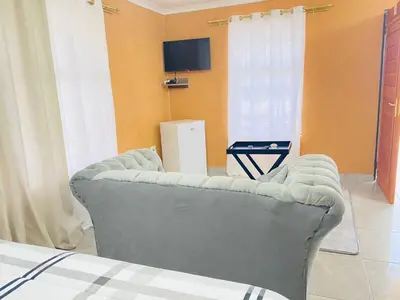 a living room with a couch and a tv at Muzee Wethu Accommodations in Armburg