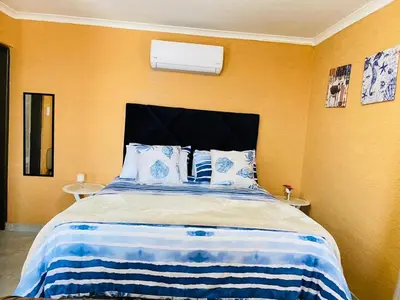 a bedroom with a large bed with blue and white sheets at Muzee Wethu Accommodations in Armburg