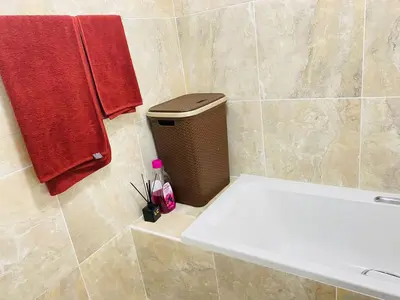 a bathroom with a white tub and a red towel at Muzee Wethu Accommodations in Armburg
