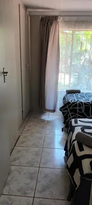 a room with two beds and a window at 15 Rottweiler Contractors Self-Catering in Pretoria