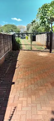 a brick sidewalk next to a black fence at 15 Rottweiler Contractors Self-Catering in Pretoria