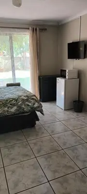 a bedroom with a bed and a tiled floor at 15 Rottweiler Contractors Self-Catering in Pretoria