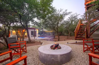 a fire pit in a yard with chairs and a house at The Suite Luxury Safari Villa, Close to KNP, Starbed, Giraffe-Feeding-Tower, Bush-Bath in Marloth Park