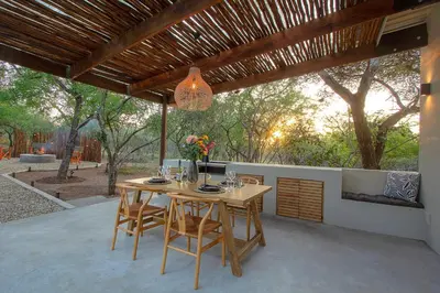 a wooden table and chairs on a patio at The Suite Luxury Safari Villa, Close to KNP, Starbed, Giraffe-Feeding-Tower, Bush-Bath in Marloth Park