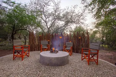 a group of chairs sitting around a fire pit at The Suite Luxury Safari Villa, Close to KNP, Starbed, Giraffe-Feeding-Tower, Bush-Bath in Marloth Park