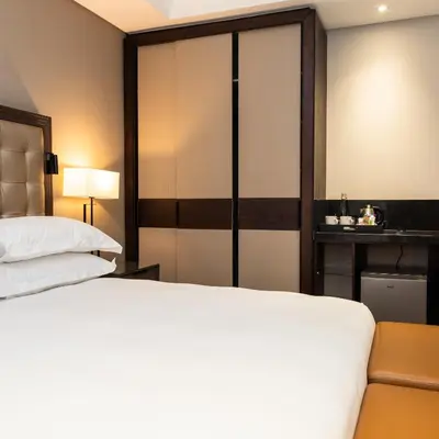 a bedroom with a bed and a large closet at Premier Hotel Thohoyandou in Thohoyandou