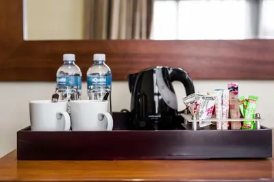 a tray with two bottles of water and two cups at Premier Hotel Thohoyandou in Thohoyandou