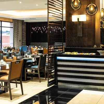 a dining room with tables and chairs in a restaurant at Premier Hotel Thohoyandou in Thohoyandou