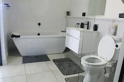 a bathroom with a toilet and a bath tub and a toilet at The Blyde in Pretoria