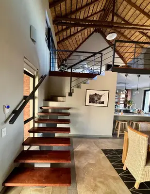 a staircase in a living room with a stair case at Serengeti Lodge Mabalingwe in Mabula