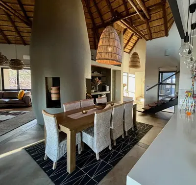 a dining room with a wooden table and chairs at Serengeti Lodge Mabalingwe in Mabula