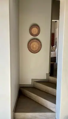 a hallway with a staircase with two baskets on the wall at Serengeti Lodge Mabalingwe in Mabula