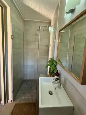 a bathroom with a white sink and a shower at Serengeti Lodge Mabalingwe in Mabula