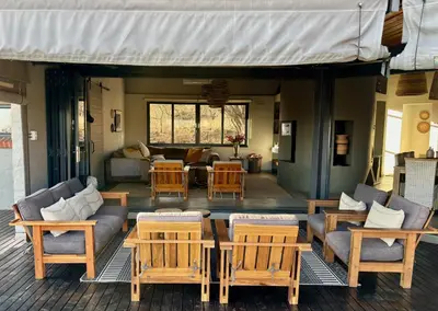 a living room with a couch and tables and chairs at Serengeti Lodge Mabalingwe in Mabula