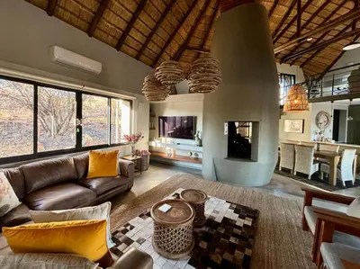a living room with a couch and a fireplace at Serengeti Lodge Mabalingwe in Mabula