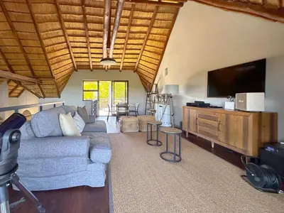 a living room with a couch and a flat screen tv at Serengeti Lodge Mabalingwe in Mabula