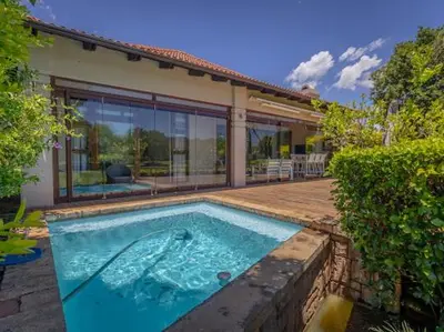 a swimming pool in front of a house at Golf & Leisure Delight - Pecanwood Golf Estate - Hartbeespoort in Hartbeespoort