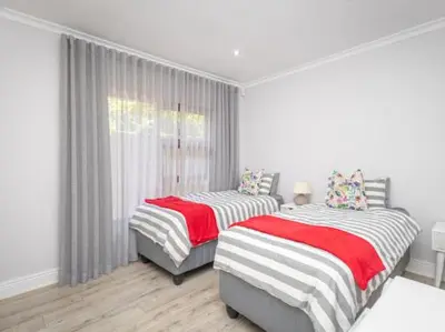 a white room with two beds and a window at Golf & Leisure Delight - Pecanwood Golf Estate - Hartbeespoort in Hartbeespoort