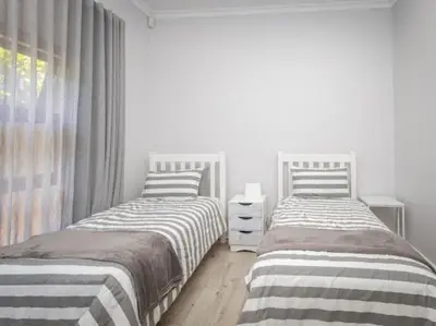 two twin beds in a room with a window at Golf & Leisure Delight - Pecanwood Golf Estate - Hartbeespoort in Hartbeespoort