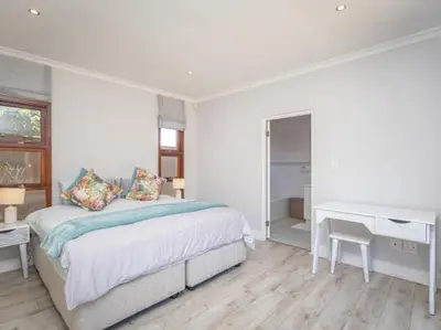 a white bedroom with a bed and a desk at Golf & Leisure Delight - Pecanwood Golf Estate - Hartbeespoort in Hartbeespoort