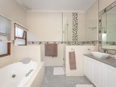 a white bathroom with a tub and a sink at Golf & Leisure Delight - Pecanwood Golf Estate - Hartbeespoort in Hartbeespoort