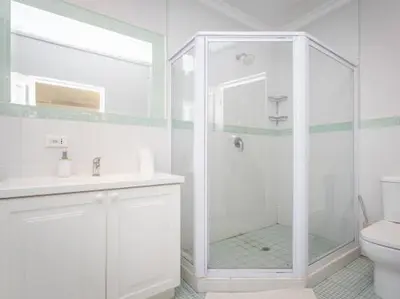 a white bathroom with a shower and a toilet at Golf & Leisure Delight - Pecanwood Golf Estate - Hartbeespoort in Hartbeespoort
