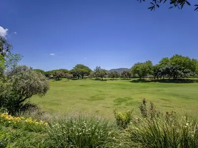 a large green field with trees in the distance at Golf & Leisure Delight - Pecanwood Golf Estate - Hartbeespoort in Hartbeespoort