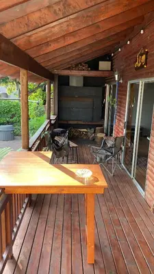 a wooden deck with a table and chairs on it at Cozy Wood Retreat in Centurion