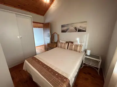 a small bedroom with a bed in a room at Cozy Wood Retreat in Centurion