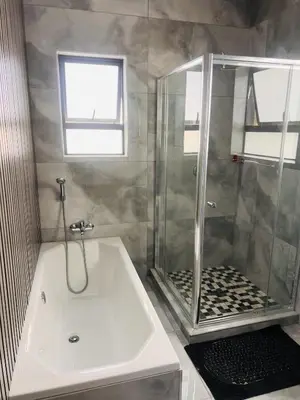 a bathroom with a shower and a white tub at Zindiza Guesthouse 2 in Witbank