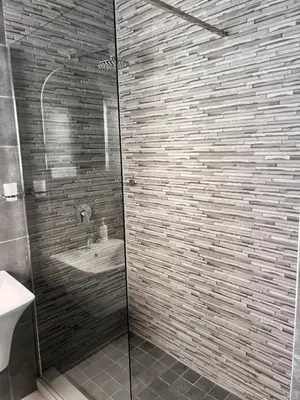a bathroom with a glass shower with a sink at Zindiza Guesthouse 2 in Witbank