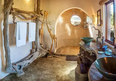 a bathroom with a large mirror and a sink at Motswari African Retreat & Walking Safaris by NEWMARK in Timbavati Game Reserve
