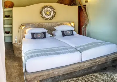 a bedroom with a bed with white sheets and pillows at Motswari African Retreat & Walking Safaris by NEWMARK in Timbavati Game Reserve