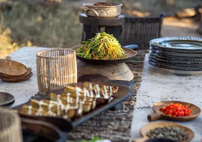 a table with plates of food and plates of food at Motswari African Retreat & Walking Safaris by NEWMARK in Timbavati Game Reserve