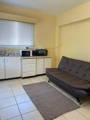a living room with a couch and a kitchen at Divine Sleep in Bela-Bela