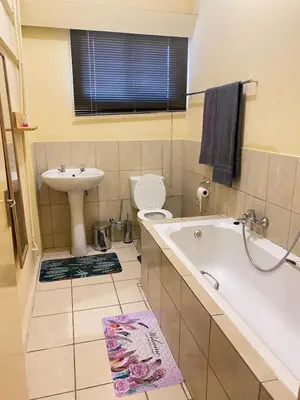 a bathroom with a tub and a sink and a toilet at Divine Sleep in Bela-Bela