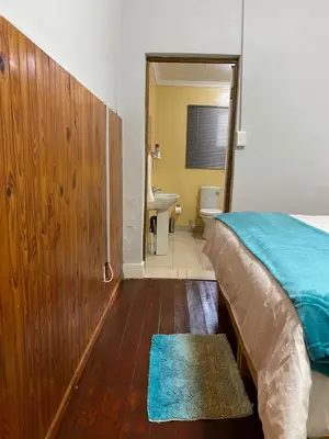 a bedroom with a bed and a bathroom with a sink at Divine Sleep in Bela-Bela