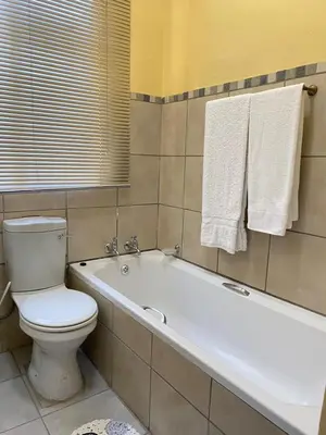 a bathroom with a toilet and a bath tub at Divine Sleep in Bela-Bela