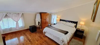 a bedroom with a bed and a large window at Die Boma Eenheid in Rayton