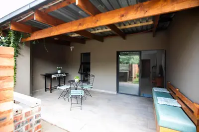 a patio with a table and chairs and a dining room at Buchan's corner Unit 1 in Hartbeespoort