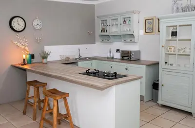 a kitchen with a counter and two stools in it at Buchan's corner Unit 1 in Hartbeespoort
