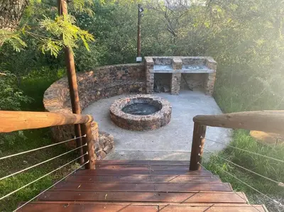 a stone fire pit in a yard with a bench at 22 Siyanda Mabalingwe in Mabula