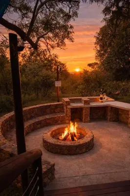 a fire pit with a sunset in the background at 22 Siyanda Mabalingwe in Mabula