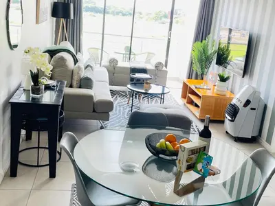 a living room with a glass table with a bowl of fruit on it at 2Bedroom Luxury Family Living Space in Midrand in Midrand