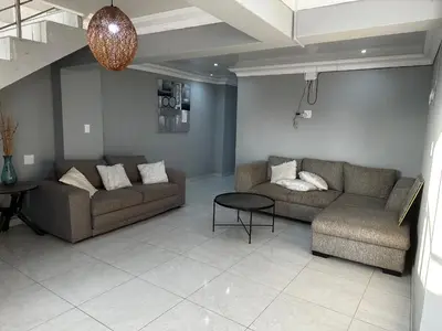 a living room with two couches and a table at RANTI Guest House in Ga-Mothiba