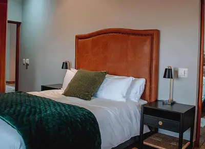 a bedroom with a large bed with a wooden headboard at 848 at Highland Gate by Euphoric Leisure in Dullstroom