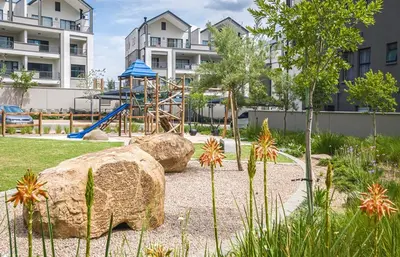 a playground in a park with rocks and a slide at Waterfall Paradise Entire Executive 1 Bed Apt in Midrand