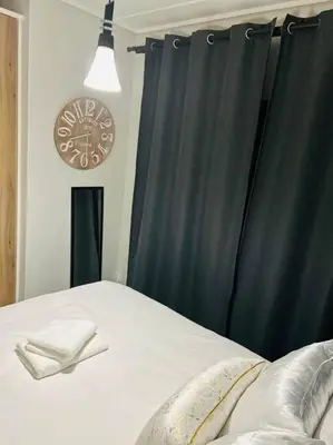 a bedroom with a black curtain and a clock at Waterfall Paradise Entire Executive 1 Bed Apt in Midrand