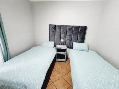 two beds in a small room with at Lions Haven in Pretoria