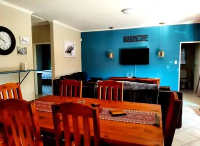 a living room with a table and a dining room at Maningwe in Marloth Park